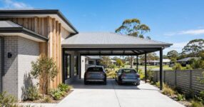 Modern double carport with light grey Colorbond steel skillion roof attached to a suburban Australian home, two cars parked underneath