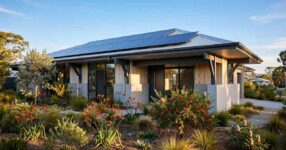 Modern Australian house with rooftop solar panels surrounded by landscaped gardens