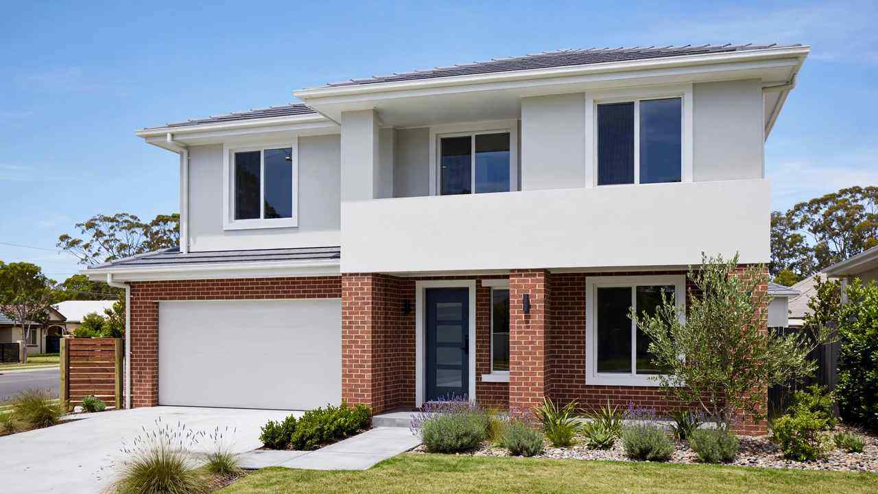 Freshly painted two-storey Australian brick home with clean rendered facade