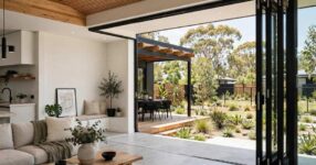 Modern home extension with large glass sliding doors opening to backyard