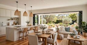 Bright open-plan living room with dining area, large windows and sliding glass doors opening to the outdoors