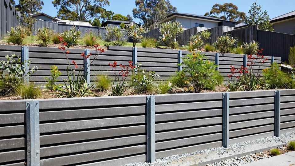 Modern concrete sleeper retaining wall with terraced garden beds in an Australian suburban backyard